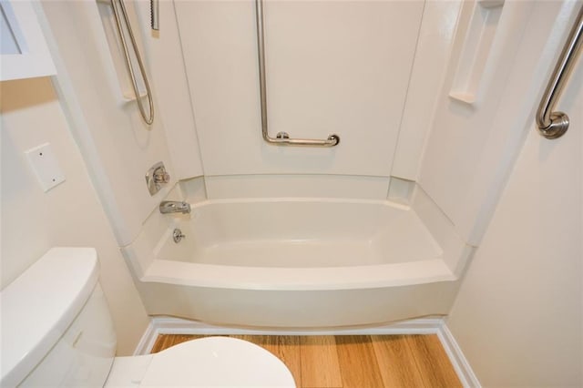 bathroom with shower / tub combination, wood-type flooring, and toilet