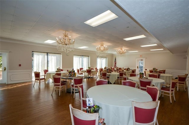 dining room featuring dark hardwood / wood-style flooring, crown molding, and a chandelier