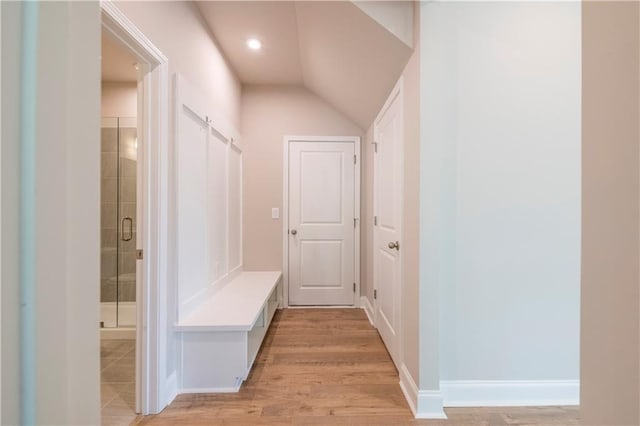 mudroom featuring light wood-type flooring and lofted ceiling