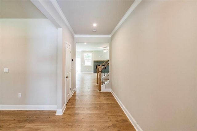 hall with crown molding and light hardwood / wood-style flooring