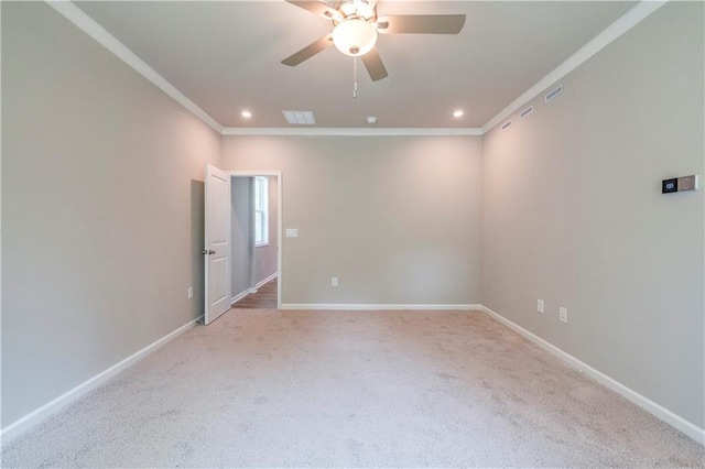 carpeted spare room with ceiling fan and crown molding