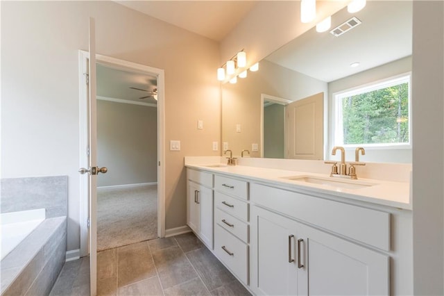 bathroom with vanity, a relaxing tiled tub, and ceiling fan