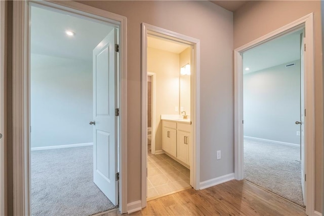 hall with light hardwood / wood-style flooring and sink