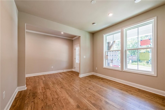 unfurnished room with light hardwood / wood-style flooring and ornamental molding