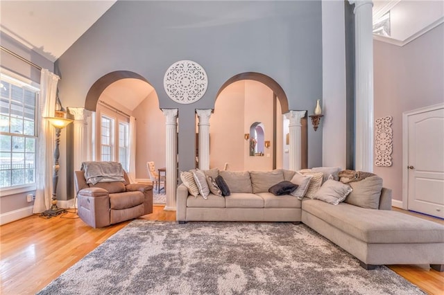 living room featuring ornate columns, high vaulted ceiling, and wood-type flooring