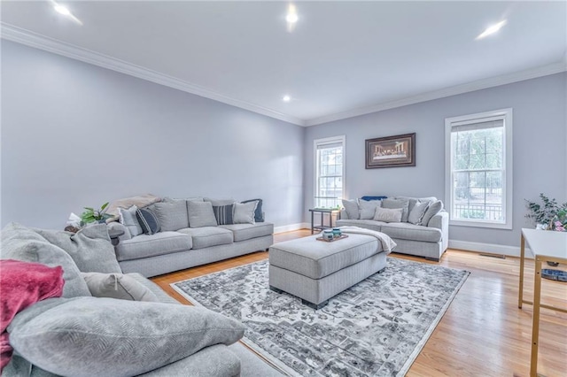 living room with crown molding and light hardwood / wood-style floors