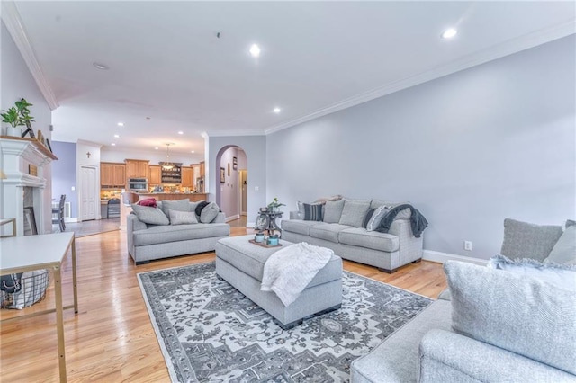 living room with ornamental molding, a notable chandelier, and light hardwood / wood-style floors