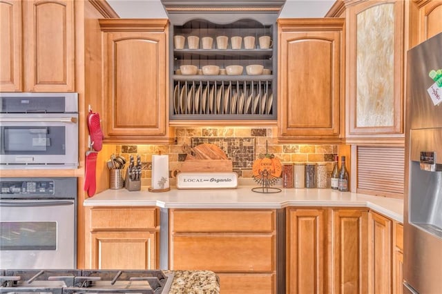 kitchen with appliances with stainless steel finishes and tasteful backsplash