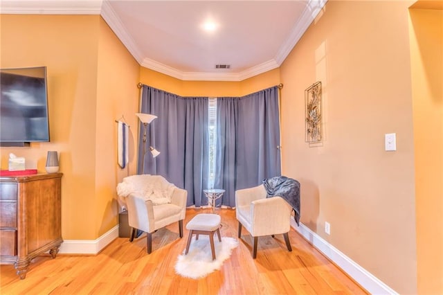 sitting room featuring wood-type flooring and crown molding