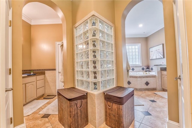 bathroom with crown molding, a relaxing tiled tub, tile patterned flooring, and vanity