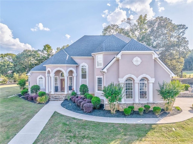 31 Meadow Lakes Ter, Cedartown, GA 30125 - french country style house featuring stucco siding, a front lawn, roof with shingles, and covered porch
