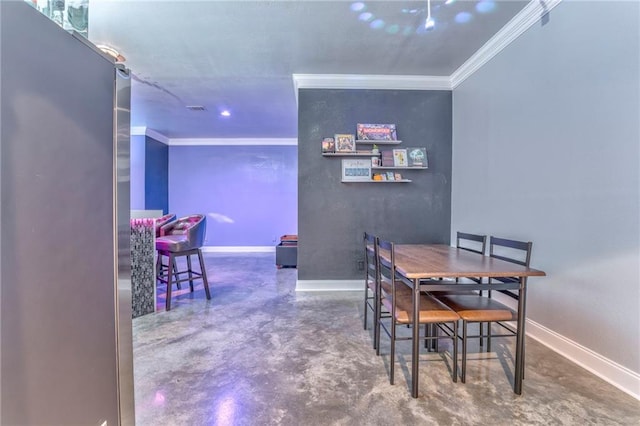 dining room featuring ornamental molding and concrete flooring