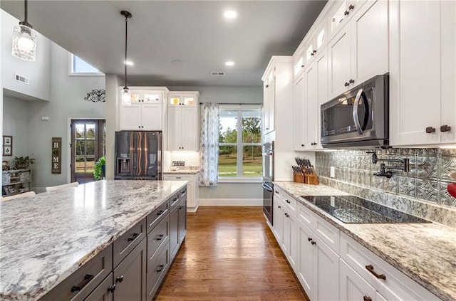 kitchen with white cabinetry, stainless steel appliances, hanging light fixtures, and dark wood-type flooring