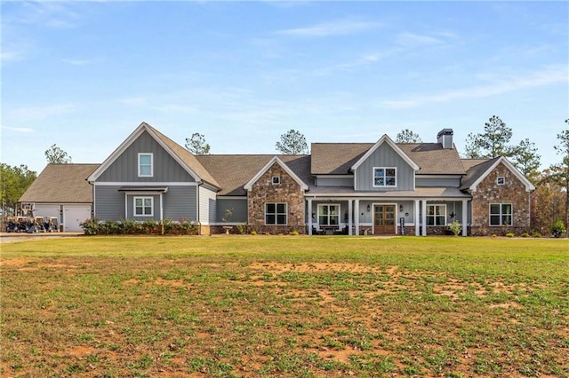 view of front facade featuring a chimney, stone siding, board and batten siding, and a front yard