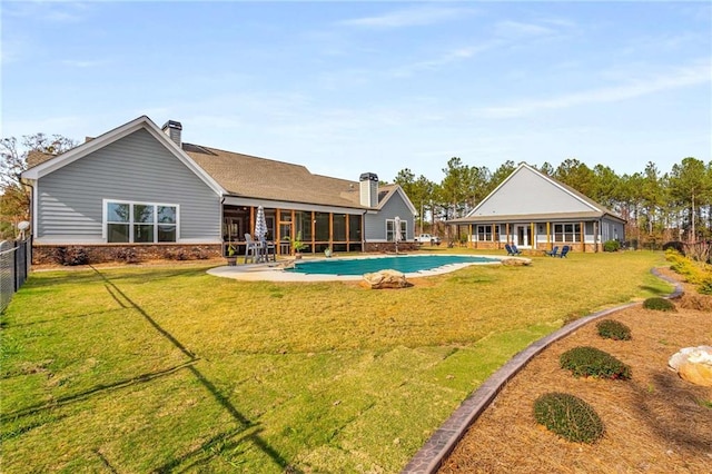 back of property with a sunroom and a lawn