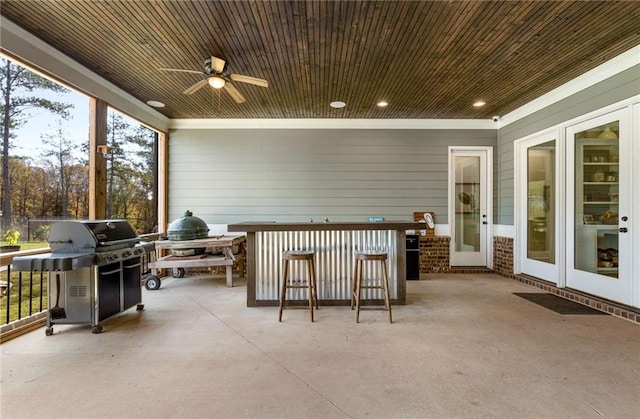 view of patio with ceiling fan, area for grilling, and exterior bar