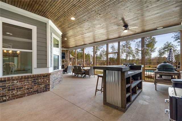 view of patio featuring area for grilling, ceiling fan, and a bar