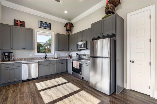 kitchen with gray cabinetry, dark wood-type flooring, sink, crown molding, and appliances with stainless steel finishes