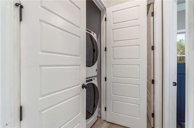 washroom featuring light wood-type flooring and stacked washer / dryer