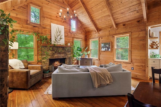 living room featuring an inviting chandelier, a fireplace, beamed ceiling, light hardwood / wood-style floors, and wood ceiling