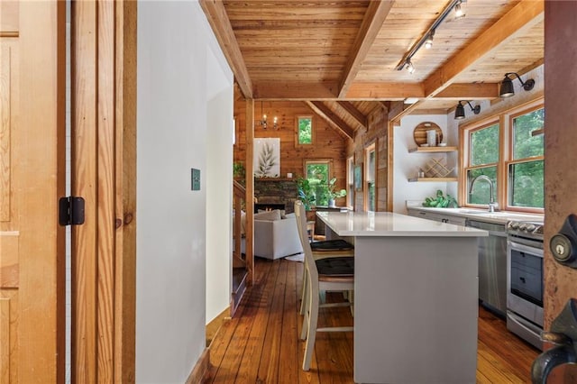 kitchen with lofted ceiling with beams, dark wood-type flooring, a sink, and wood ceiling