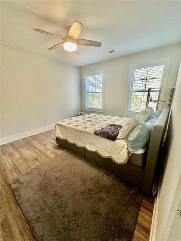 bedroom with ceiling fan and hardwood / wood-style flooring