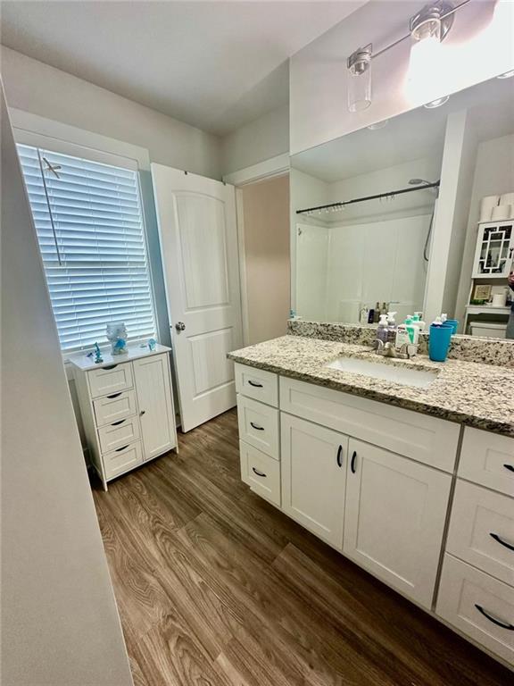 bathroom featuring a shower, wood-type flooring, and vanity