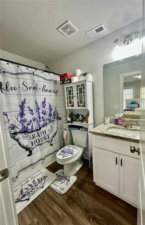 bathroom with toilet, hardwood / wood-style flooring, and vanity