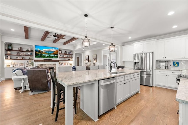 5821 Abbey View Ct, Clermont, GA 30527 - kitchen with appliances with stainless steel finishes, a center island with sink, crown molding, beam ceiling, and white cabinets