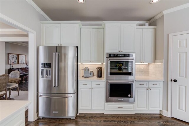 kitchen featuring appliances with stainless steel finishes, dark wood finished floors, crown molding, and white cabinetry