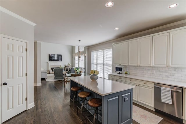 kitchen with decorative backsplash, stainless steel dishwasher, a breakfast bar area, and white cabinets