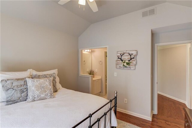 bedroom with visible vents, ensuite bath, wood finished floors, baseboards, and lofted ceiling