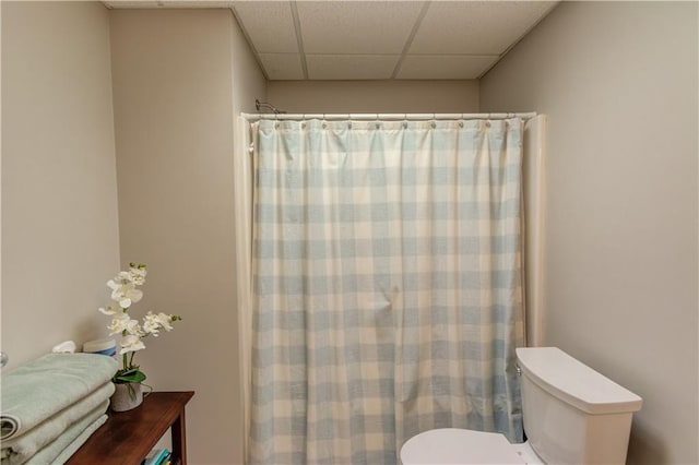 full bathroom with a shower with shower curtain, toilet, and a paneled ceiling