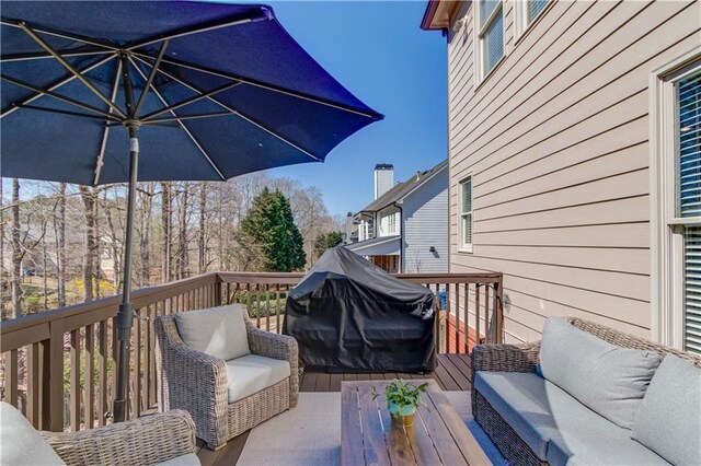 wooden deck with outdoor lounge area and a grill