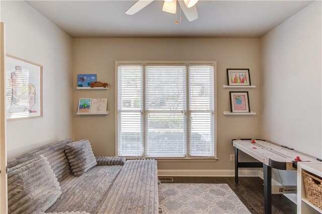 interior space with visible vents, ceiling fan, baseboards, and wood finished floors