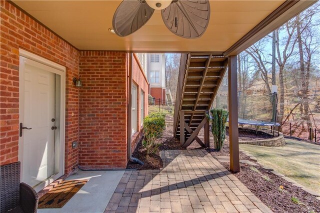 view of patio with a trampoline and fence