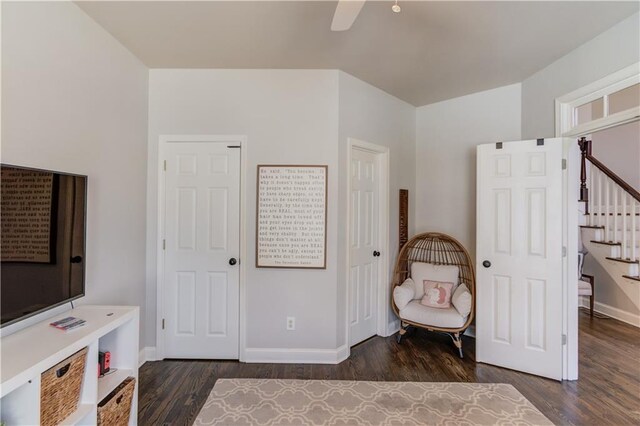 living area featuring stairway, ceiling fan, baseboards, and wood finished floors