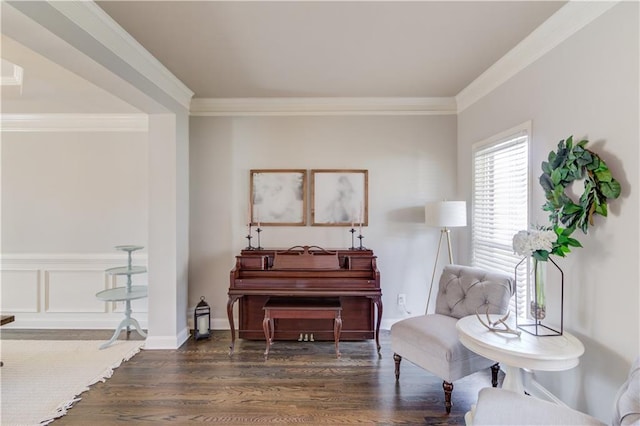 sitting room featuring baseboards, wood finished floors, and crown molding