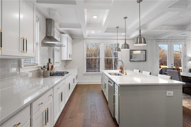 kitchen with coffered ceiling, a sink, light countertops, wall chimney range hood, and dark wood-style floors