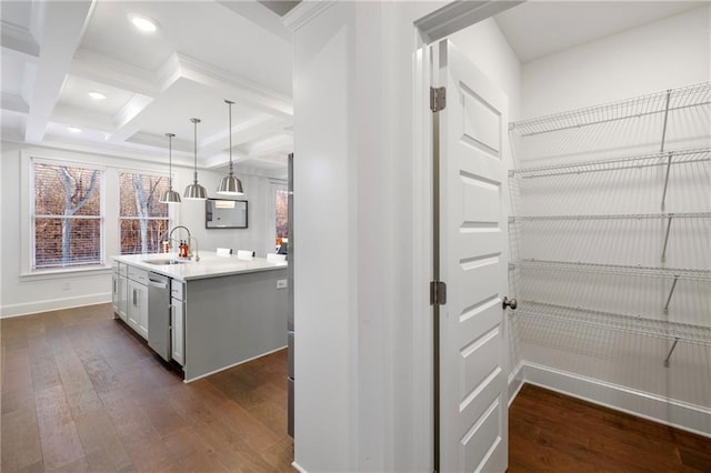 interior space with coffered ceiling, dishwasher, dark wood-type flooring, beam ceiling, and a sink