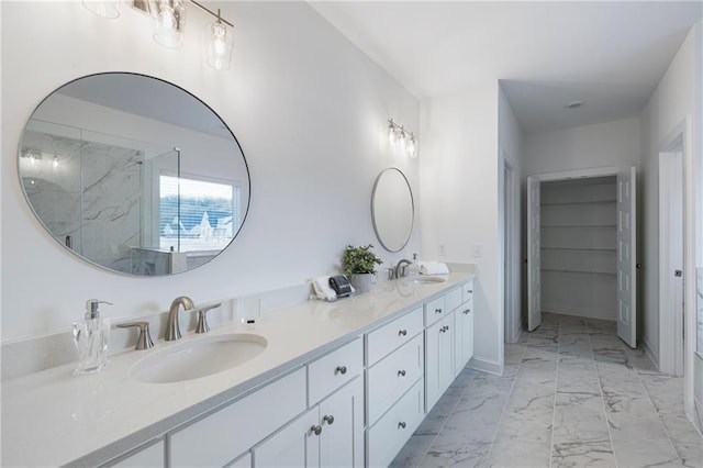 full bath with a walk in shower, marble finish floor, a sink, and double vanity