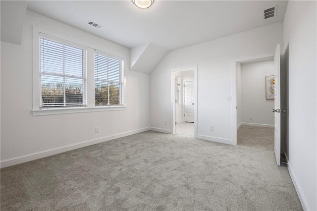 additional living space featuring carpet floors, visible vents, and baseboards