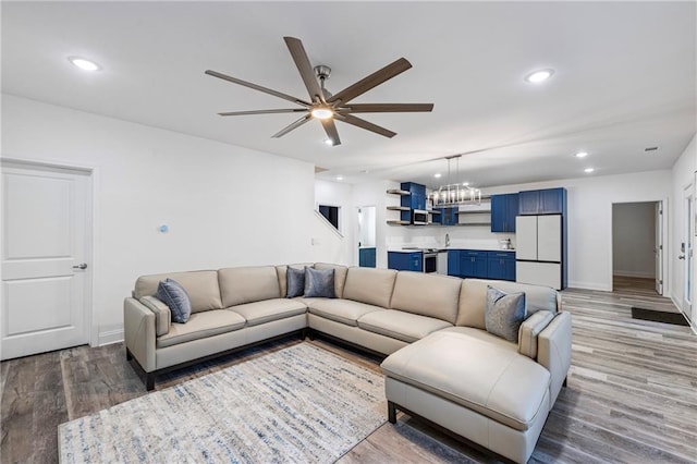 living room featuring ceiling fan, baseboards, wood finished floors, and recessed lighting