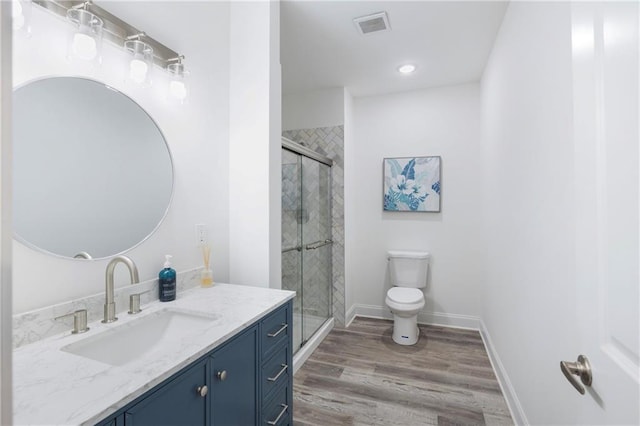 bathroom with visible vents, toilet, a shower stall, wood finished floors, and baseboards