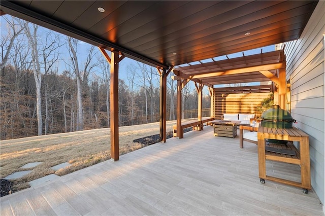 view of patio / terrace with a forest view, an outdoor living space with a fire pit, and a pergola