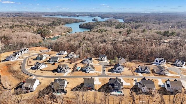 bird's eye view with a residential view, a water view, and a wooded view