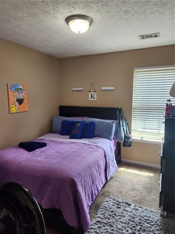 carpeted bedroom featuring a textured ceiling