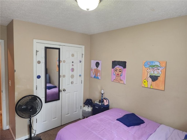 carpeted bedroom with a textured ceiling and a closet