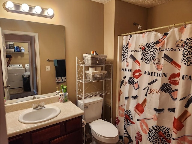 bathroom with washer and dryer, a textured ceiling, toilet, and vanity