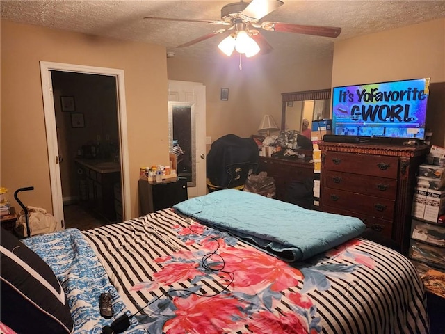 bedroom with ceiling fan, a textured ceiling, and ensuite bathroom